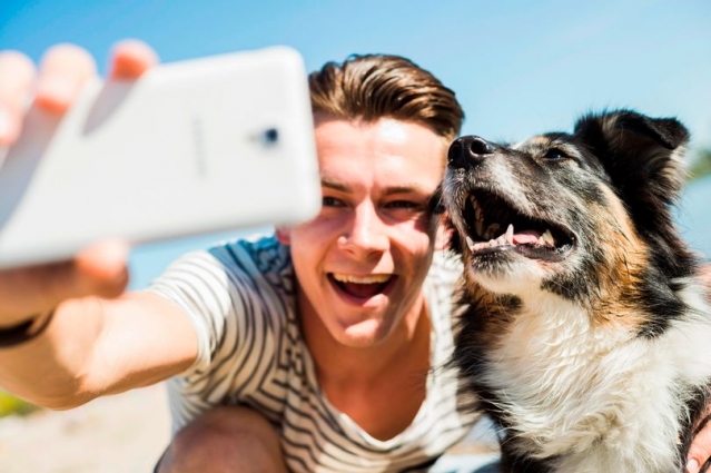 homem tirando foto com cachorro